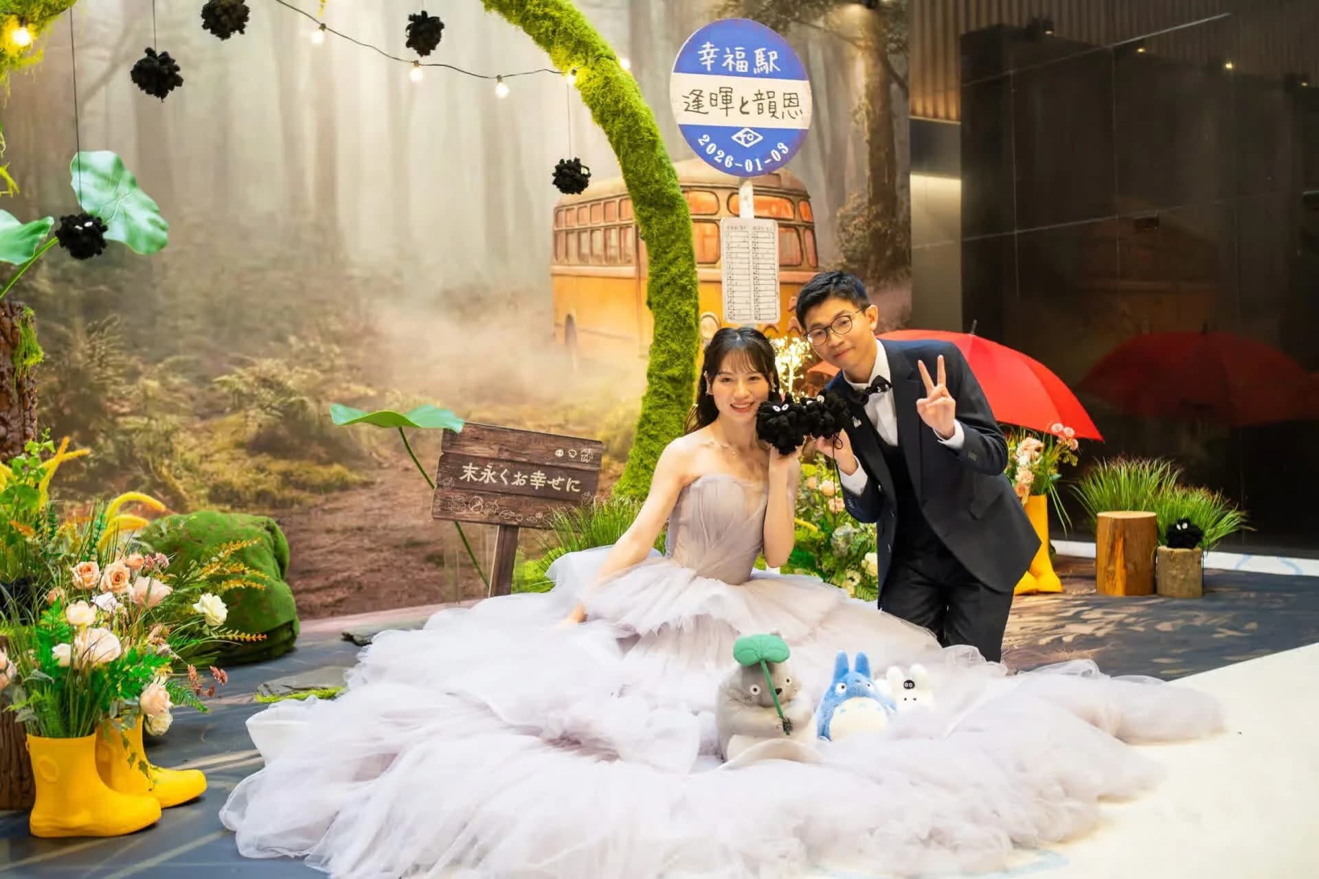 新人在龍貓主題佈景中甜蜜合影，灰紫婚紗、幸福車站，充滿童趣與浪漫。
