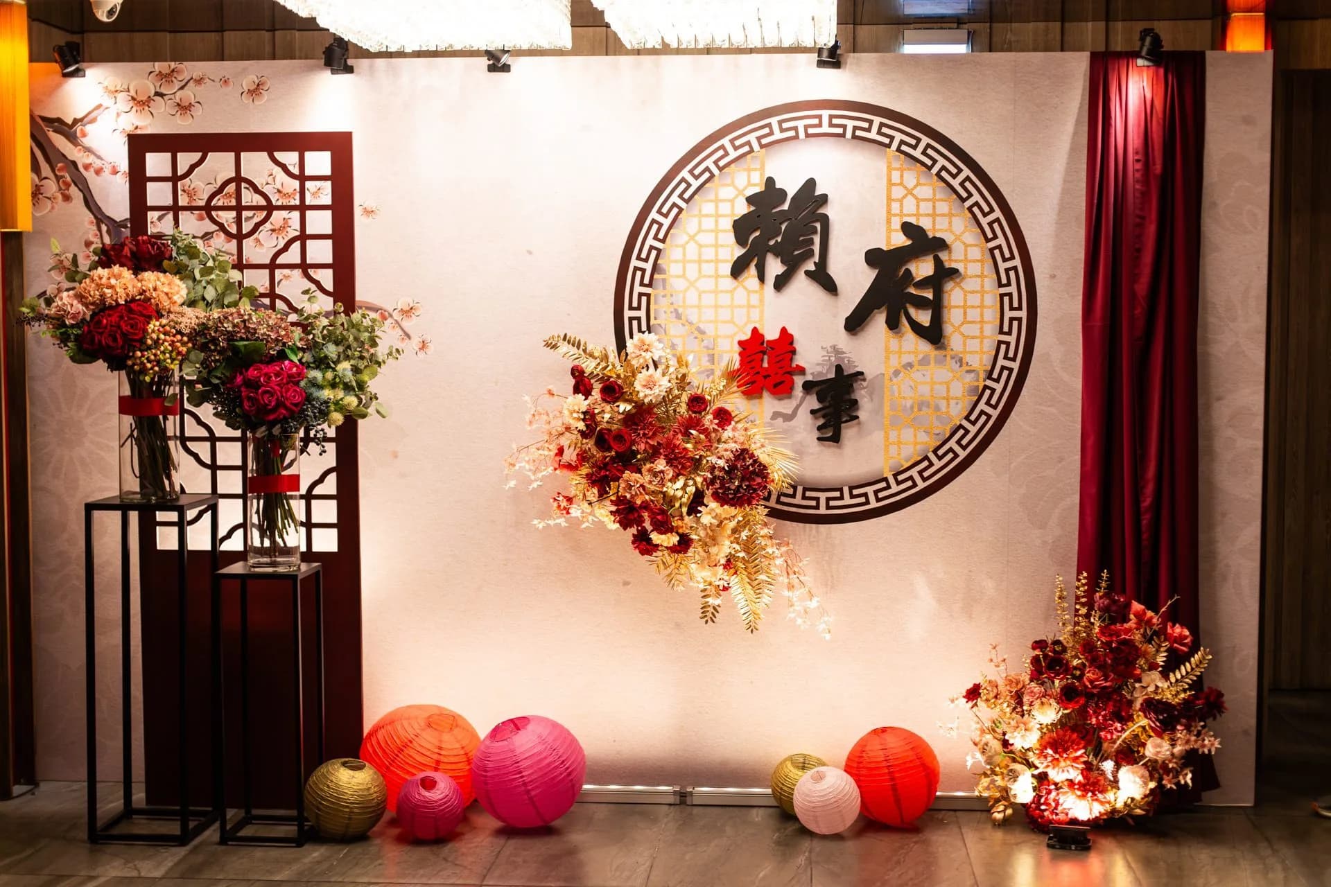 中式婚禮佈景,紅色雙囍字、花藝、燈籠,溫暖喜悅。