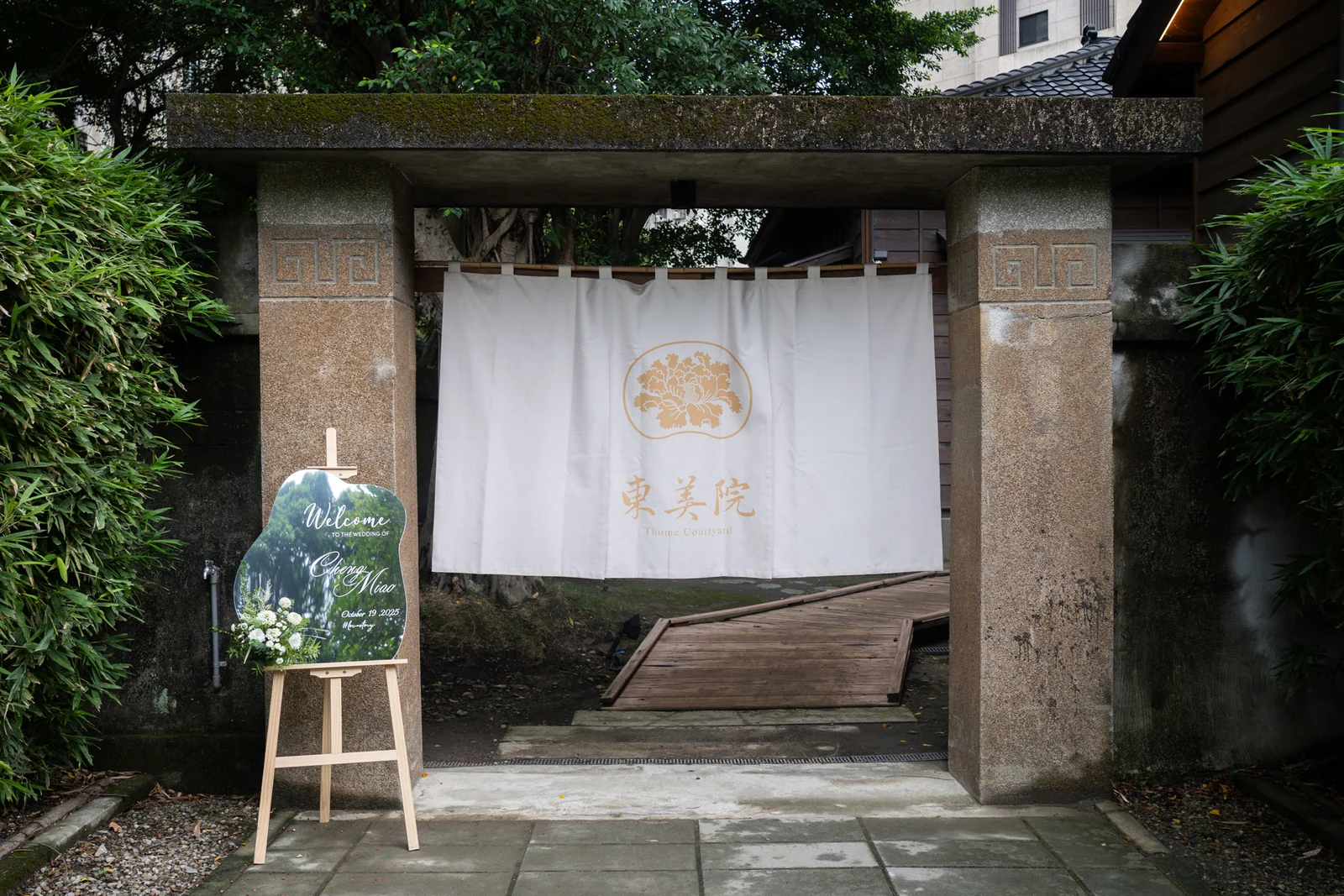東美園庭院入口的石材門框、白色布簾與鏡面迎賓牌