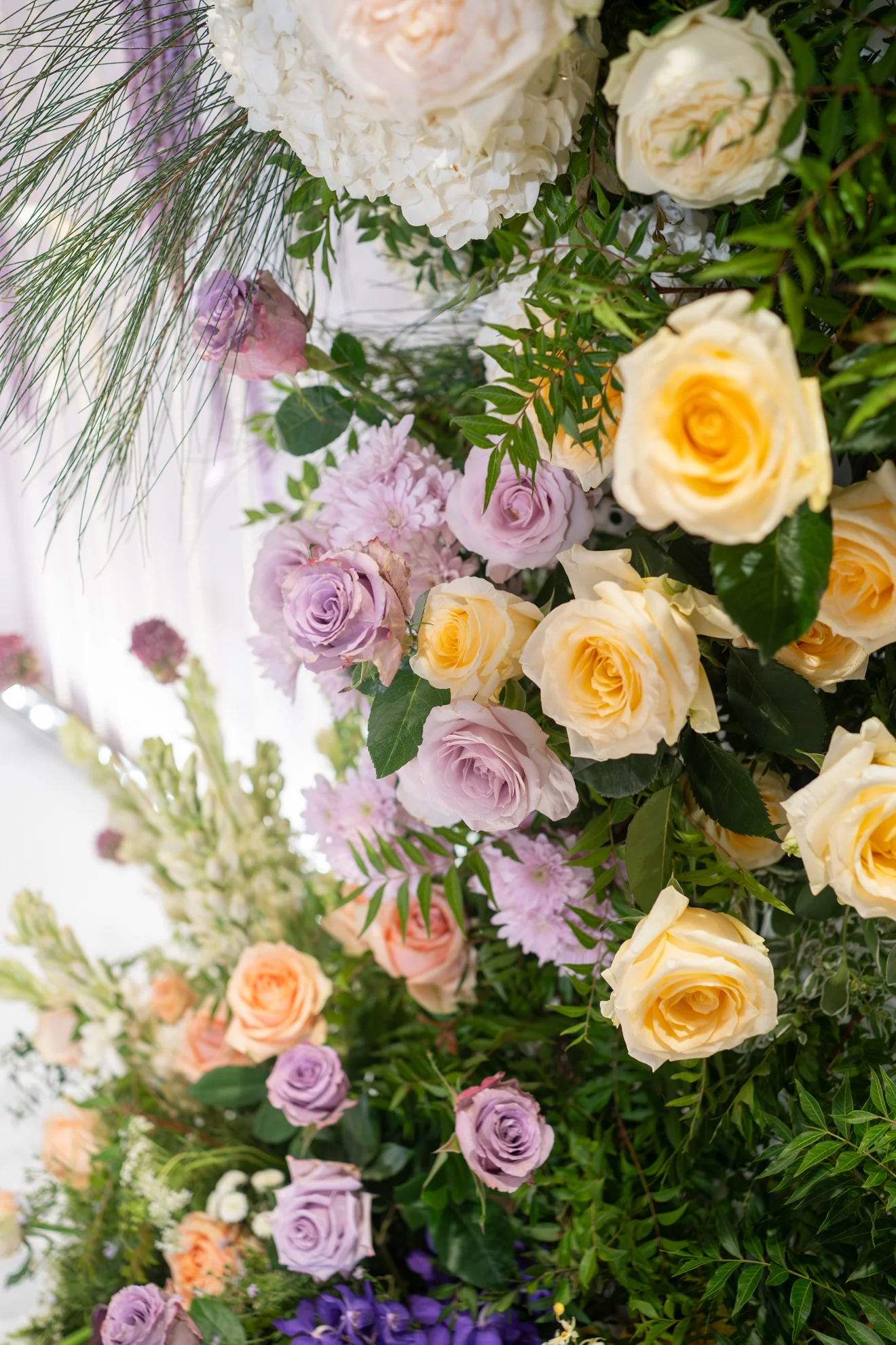 婚禮花柱近拍:粉色、奶油黃玫瑰與白花、綠葉的層次