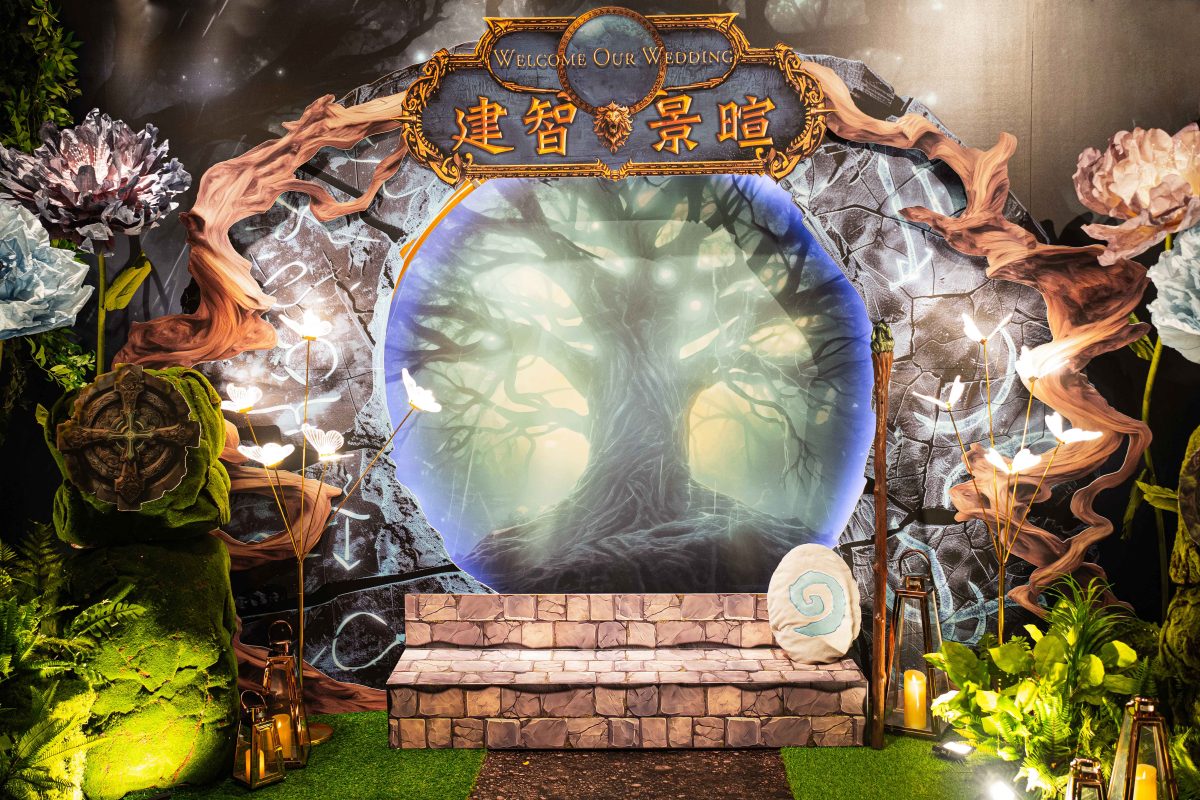 藍綠發光的森林圓拱背板前，石階與草地被燈光點亮