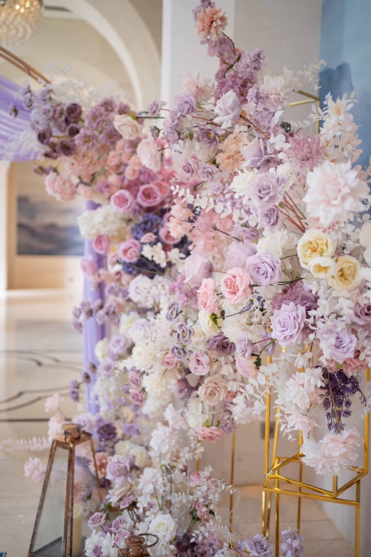 紫色花藝與拱門設計的婚禮迎賓背景，搭配雪紡紗幔打造夢幻場景